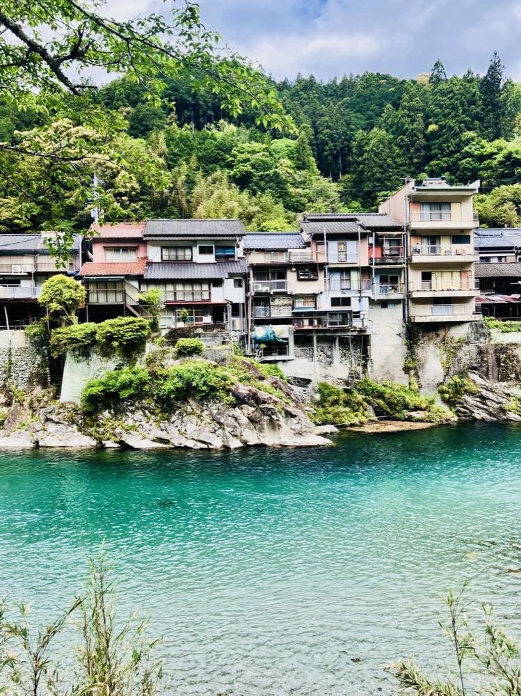 澄んだ仁淀ブルーと川沿いの町なみ